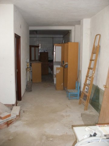 Interior view of a commercial space in Castillejar, Granada, showing unfinished walls and basic furn.