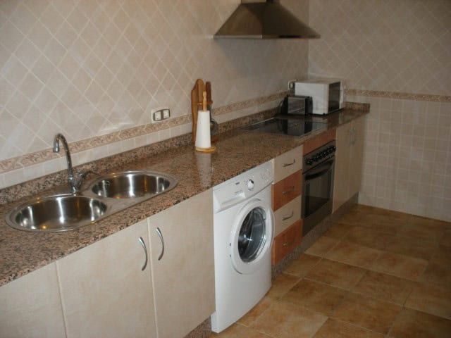 Commercial kitchen in Castillejar, Granada with appliances and granite countertops.