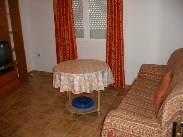 Commercial property for sale in Castillejar, Granada, featuring a cozy interior with a sofa, window,.
