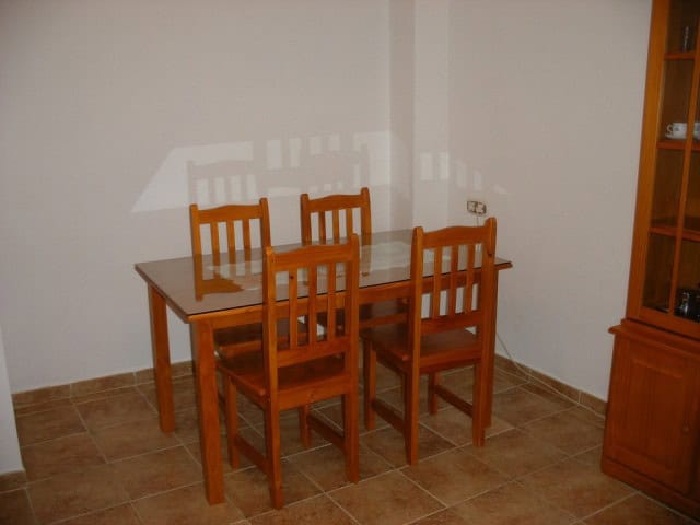 Modern wooden dining table with four chairs in a bright room for family meals.