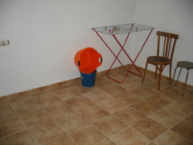 Interior of a commercial space in Castillejar, Granada with basic furnishings and tiled flooring.