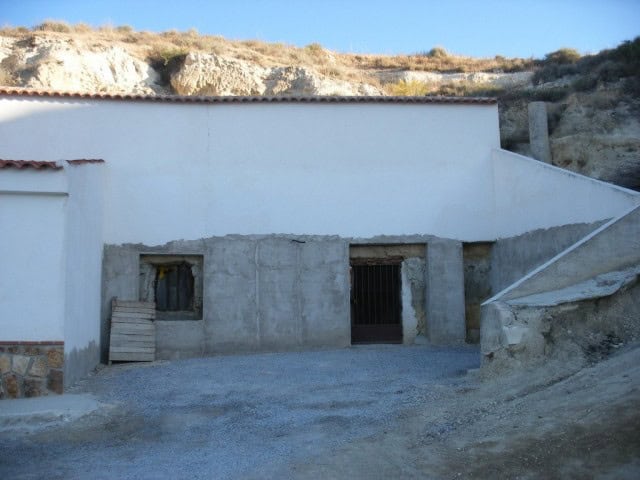 Cave house with rustic exterior and underground features in Cuevas del Campo, Granada.