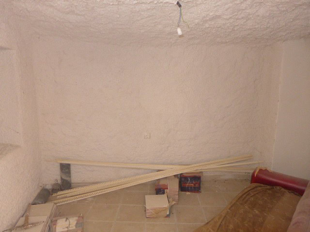Interior view of a cave house in Cuevas del Campo, Granada, showing unfinished walls and constructio.