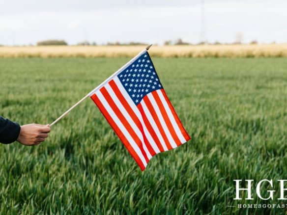 American flag waving in a lush green field, symbolizing Americans relocating to Europe.