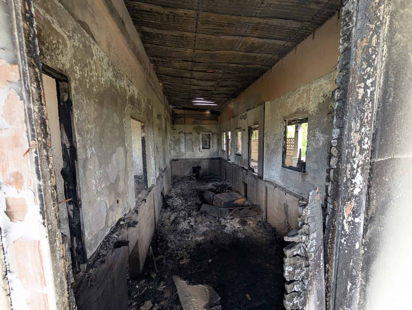 Interior of a partially burned or damaged building in Fortlands, Basseterre, Saint Kitts, showing ch.