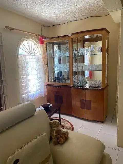 Spacious living room featuring a glass display cabinet and comfortable seating.