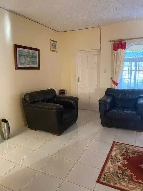 Living room with black leather sofas in a Portland estate for sale.