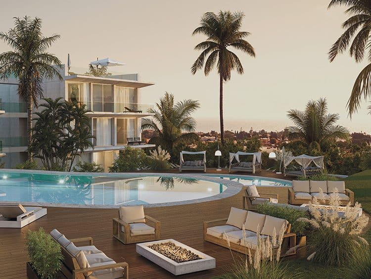 Elegant outdoor pool area with modern lounge furniture and lush palm trees in Vale do Milho, Carvoei.