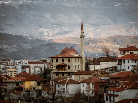 Albania real estate market with traditional houses and a mosque, ideal for foreign investors in 2026.