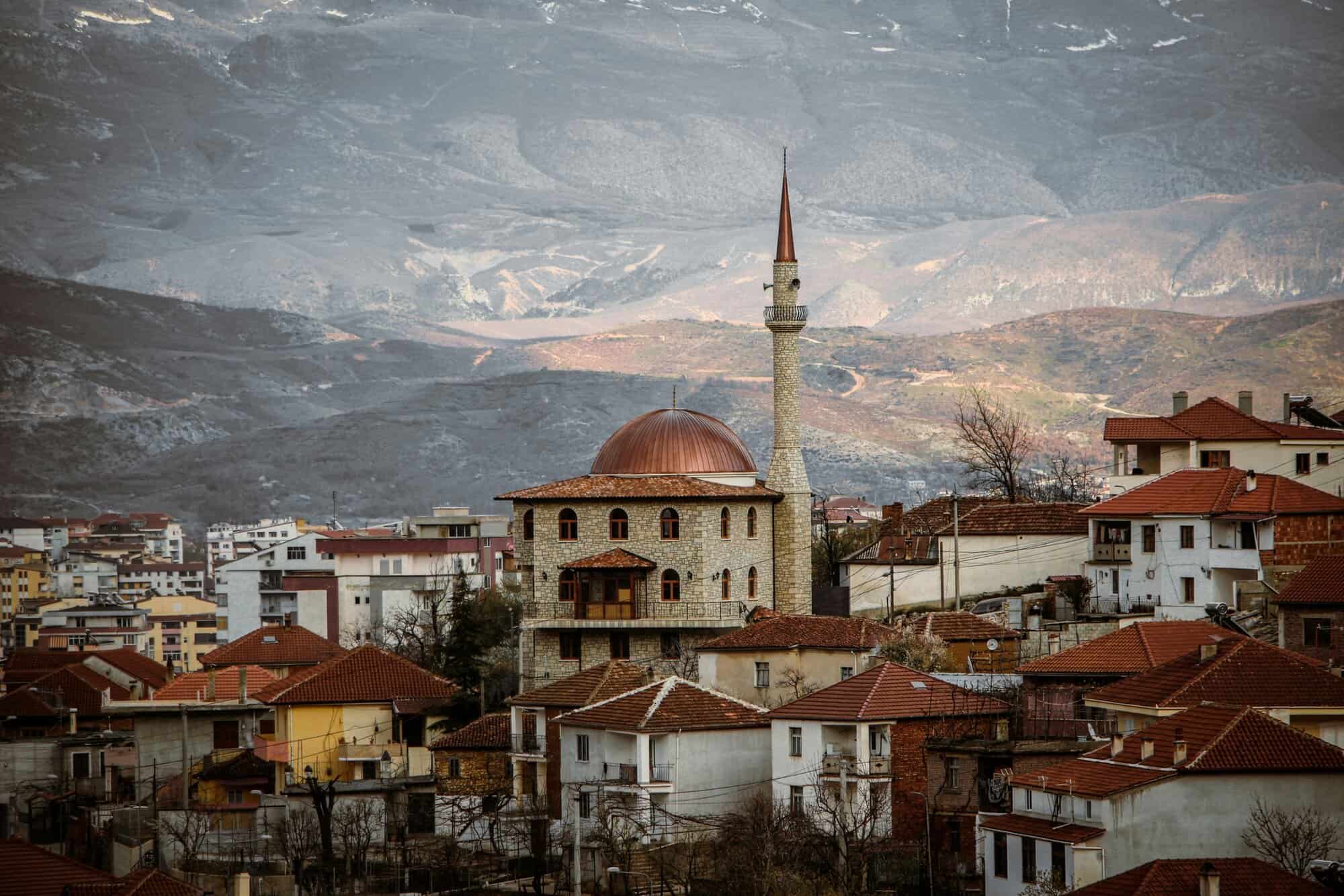 Albania real estate market with traditional houses and a mosque, ideal for foreign investors in 2026.