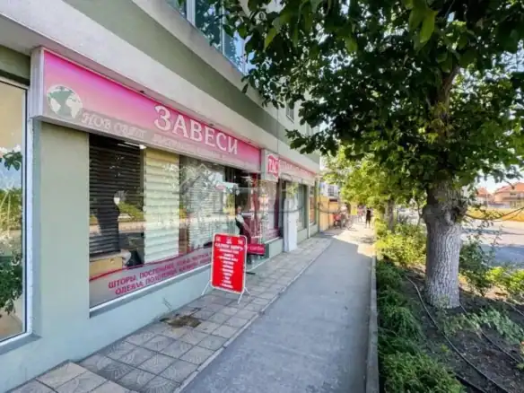Bright storefront with large windows and pink signage.