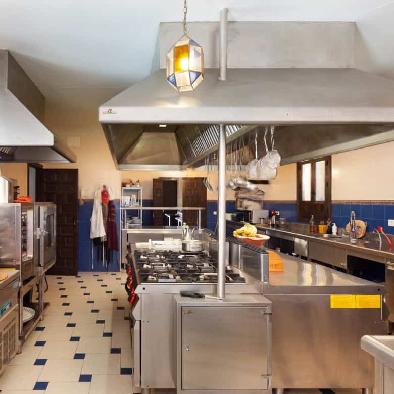 Commercial kitchen with stainless steel appliances and large work areas.