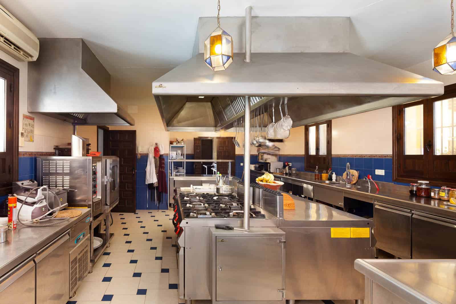 Commercial kitchen with stainless steel appliances and large work areas.