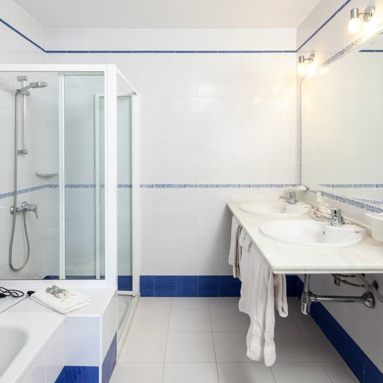 Bathroom with shower, bathtub, and double sink for comfort and convenience.