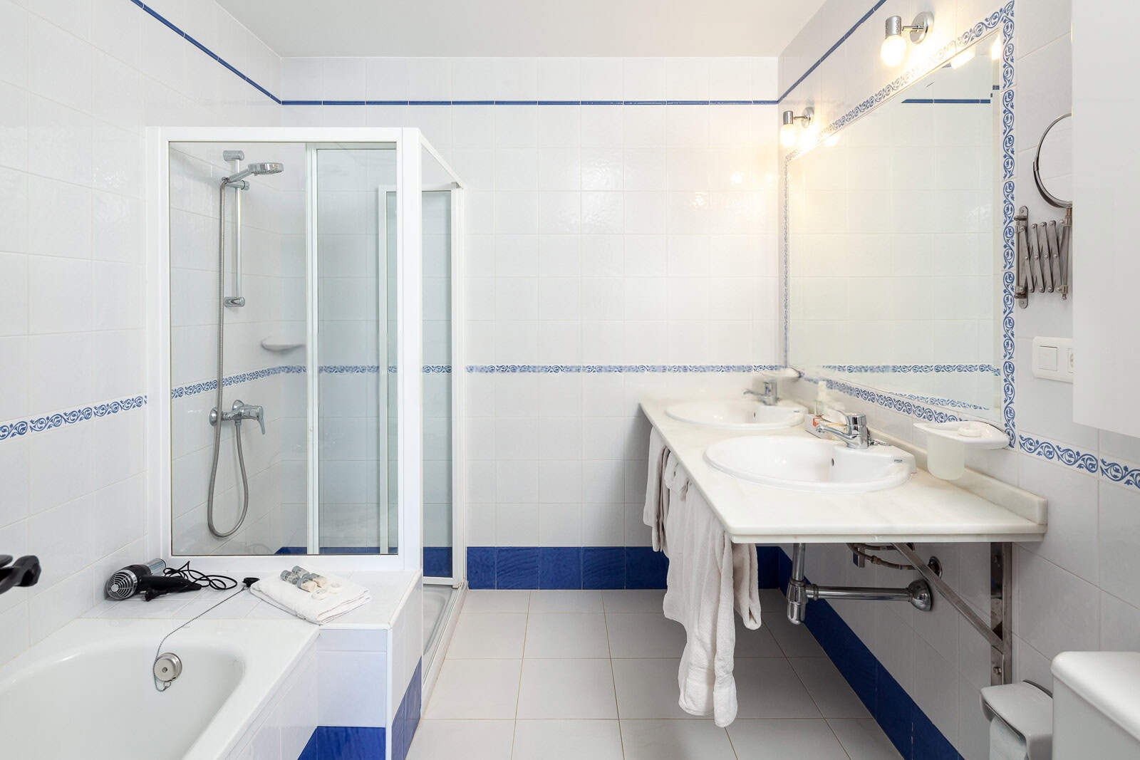 Bathroom with shower, bathtub, and double sink for comfort and convenience.