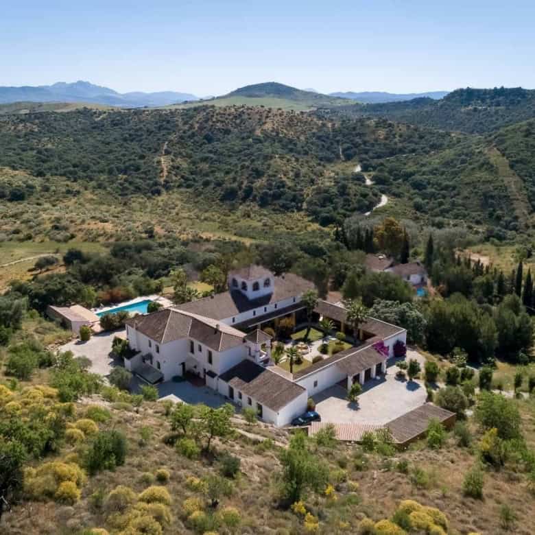 Elegant countryside villa surrounded by lush greenery and rolling hills.