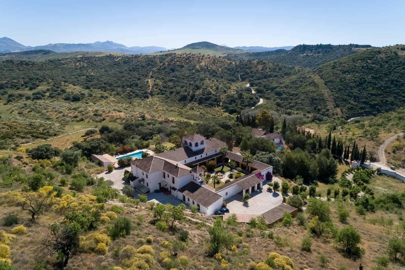 Elegant countryside villa surrounded by lush greenery and rolling hills.