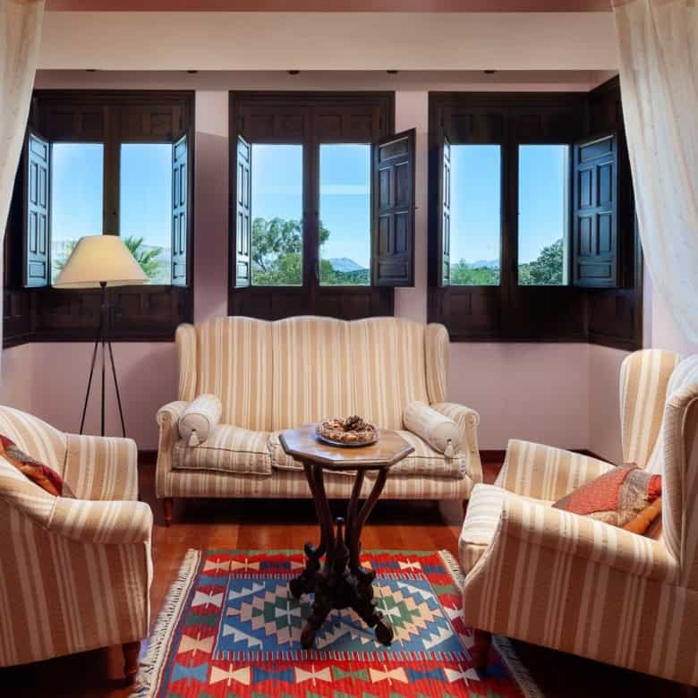 Bright living room with large open windows and elegant furniture.
