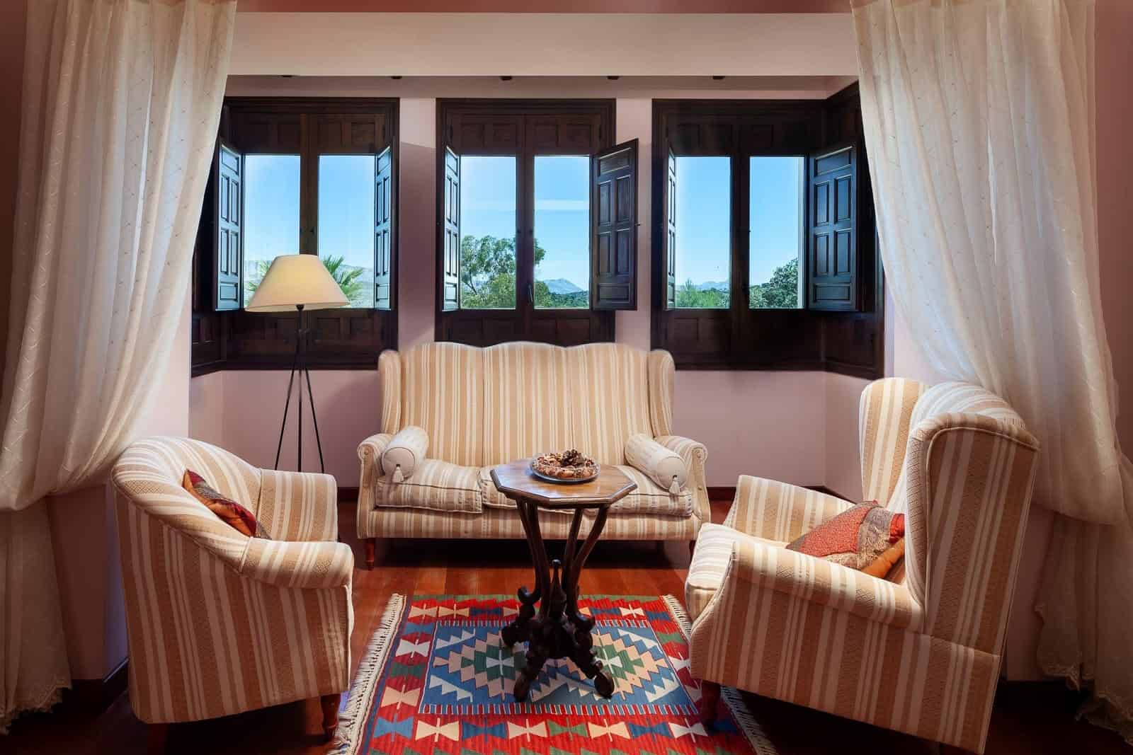 Bright living room with large open windows and elegant furniture.
