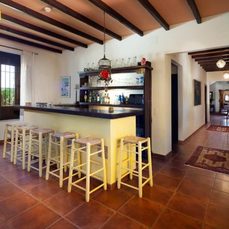 Inviting home bar with seating and warm decor in a spacious living area.
