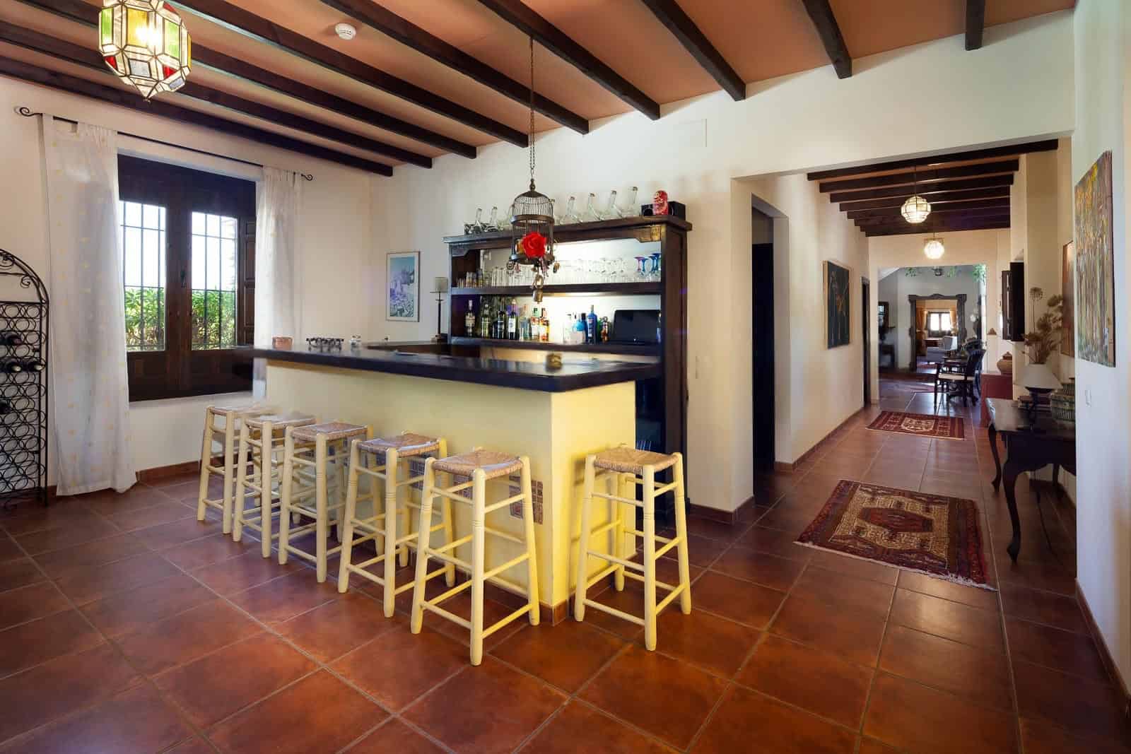 Inviting home bar with seating and warm decor in a spacious living area.