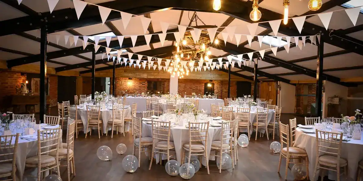 Elegant wedding reception setup with round tables and white chairs Elegant wedding reception with round tables, white chairs, and festive decorations in a stylish venu.