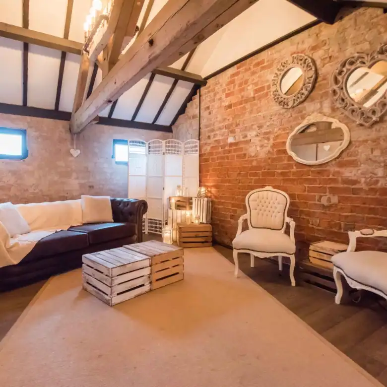 Cozy living room featuring exposed brick walls, vintage armchairs, and decorative mirrors for a rust.