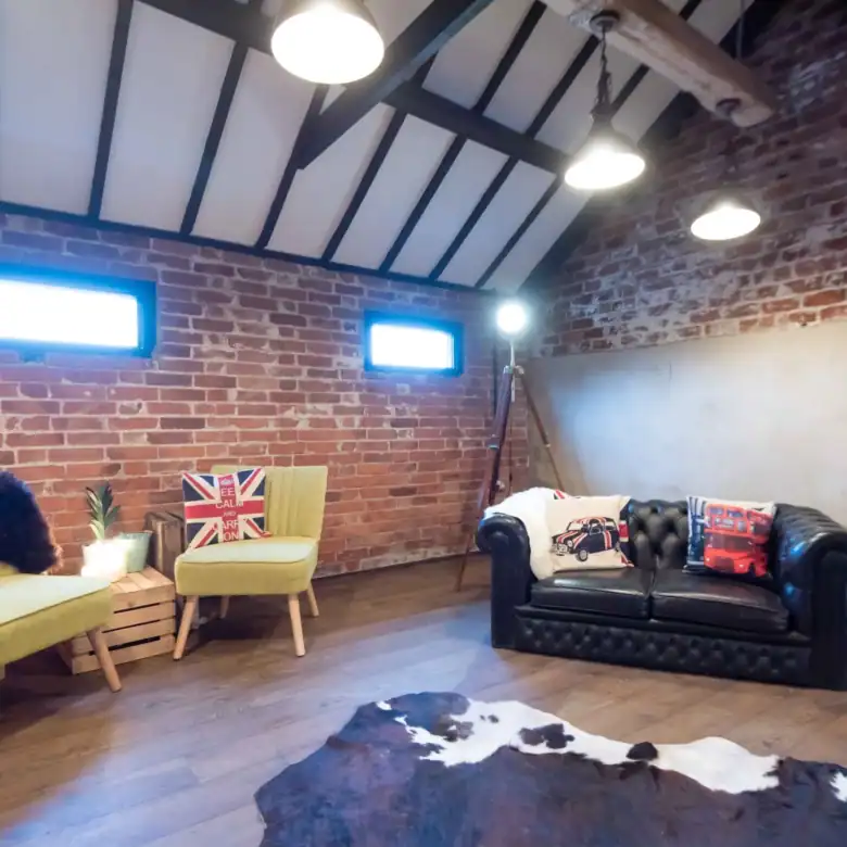 Stylish loft living room with brick walls, cozy seating, and modern decor.