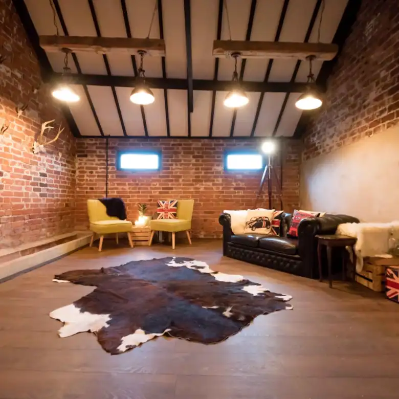 Cozy living room with brick walls, leather sofa, and vintage accents.