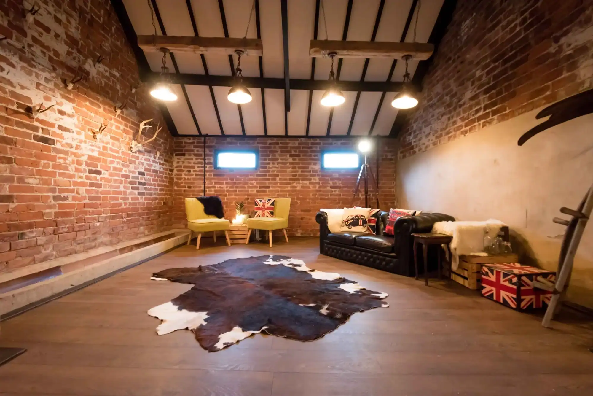 Modern rustic living room with exposed brick walls and stylish decor. Cozy living room with brick walls, leather sofa, and vintage accents.