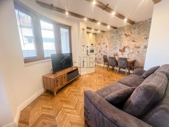 Bright living room with large windows and modern decor near Danube River.