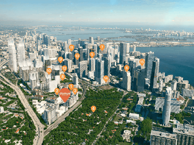 Aerial view of Brickell, Miami showcasing skyscrapers, lush parks, and waterfront scenery in a vibra.