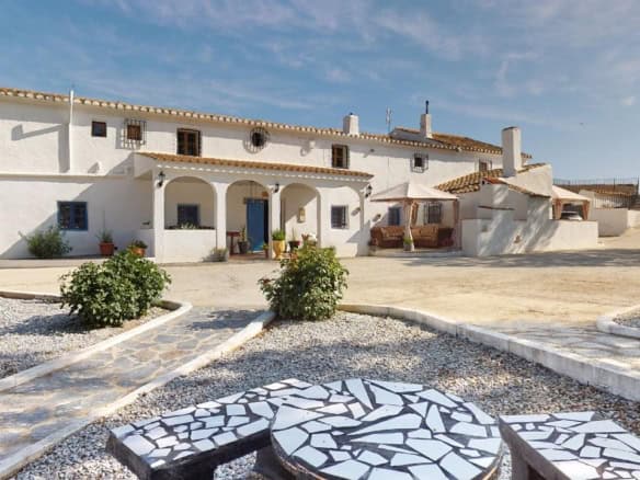 Boutique hotel for sale in Caniles, Granada, featuring traditional Spanish architecture and scenic s.