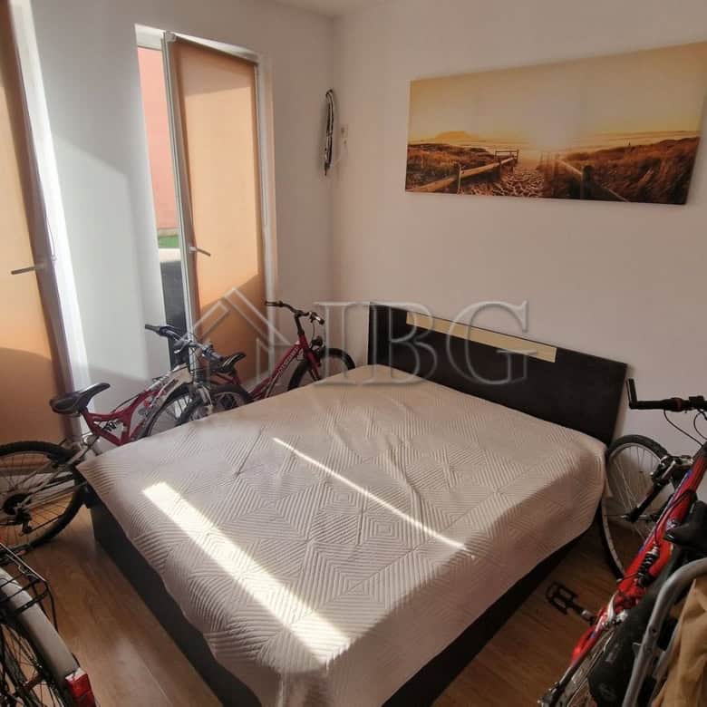Cozy bedroom with bicycles and balcony view in Sunny Beach area.