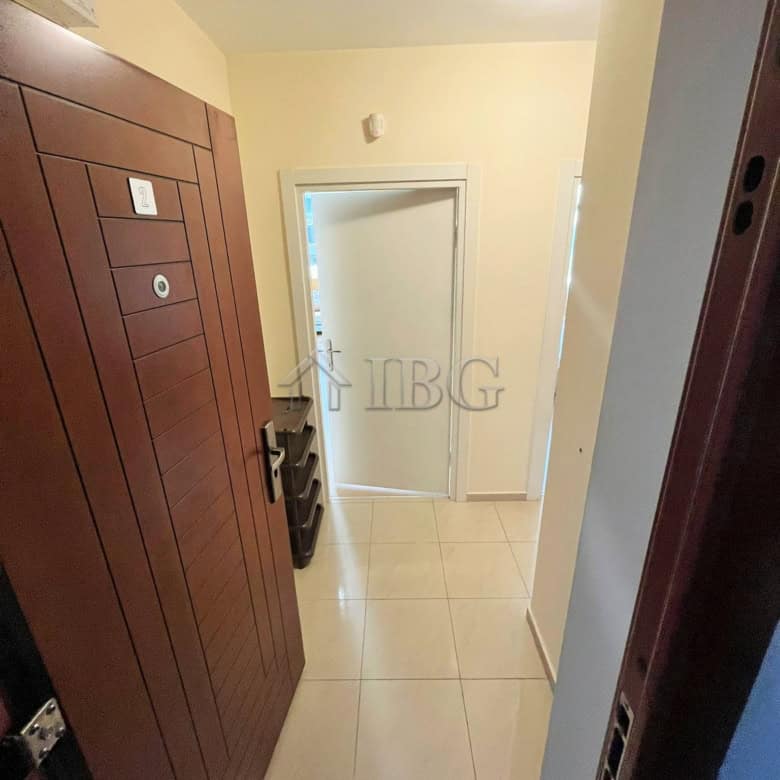 Apartment entrance with wooden wardrobe and hallway view.