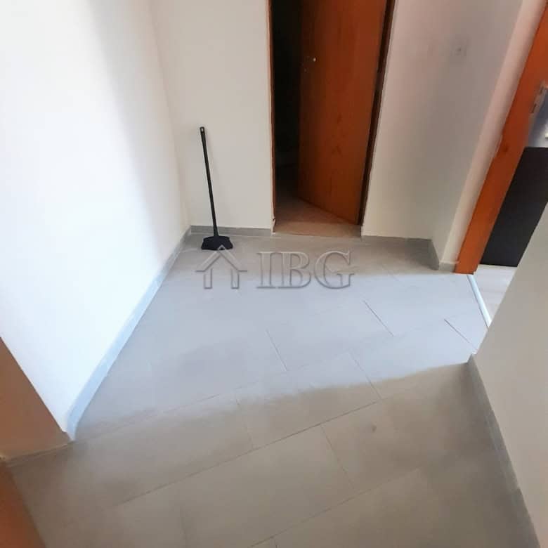 Interior view of a renovated apartment entrance with a door and cleaning tool.