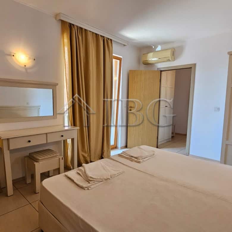 Bright bedroom in Sunny Beach apartment with wardrobe and large window.