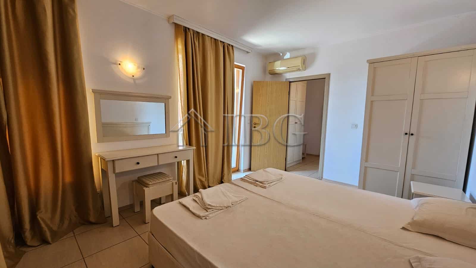 Bright bedroom in Sunny Beach apartment with wardrobe and large window.