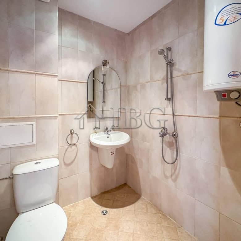 Bathroom with shower, toilet, and water heater in a Sveti Vlas apartment.