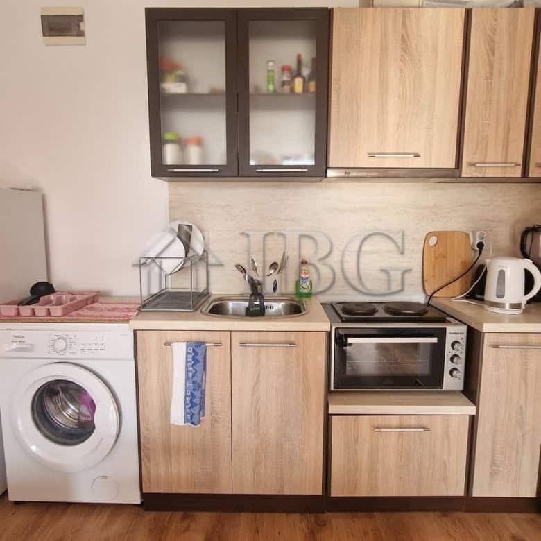 Interior view of a compact 1-bedroom apartment with kitchen and pool view in Sunny Beach area.