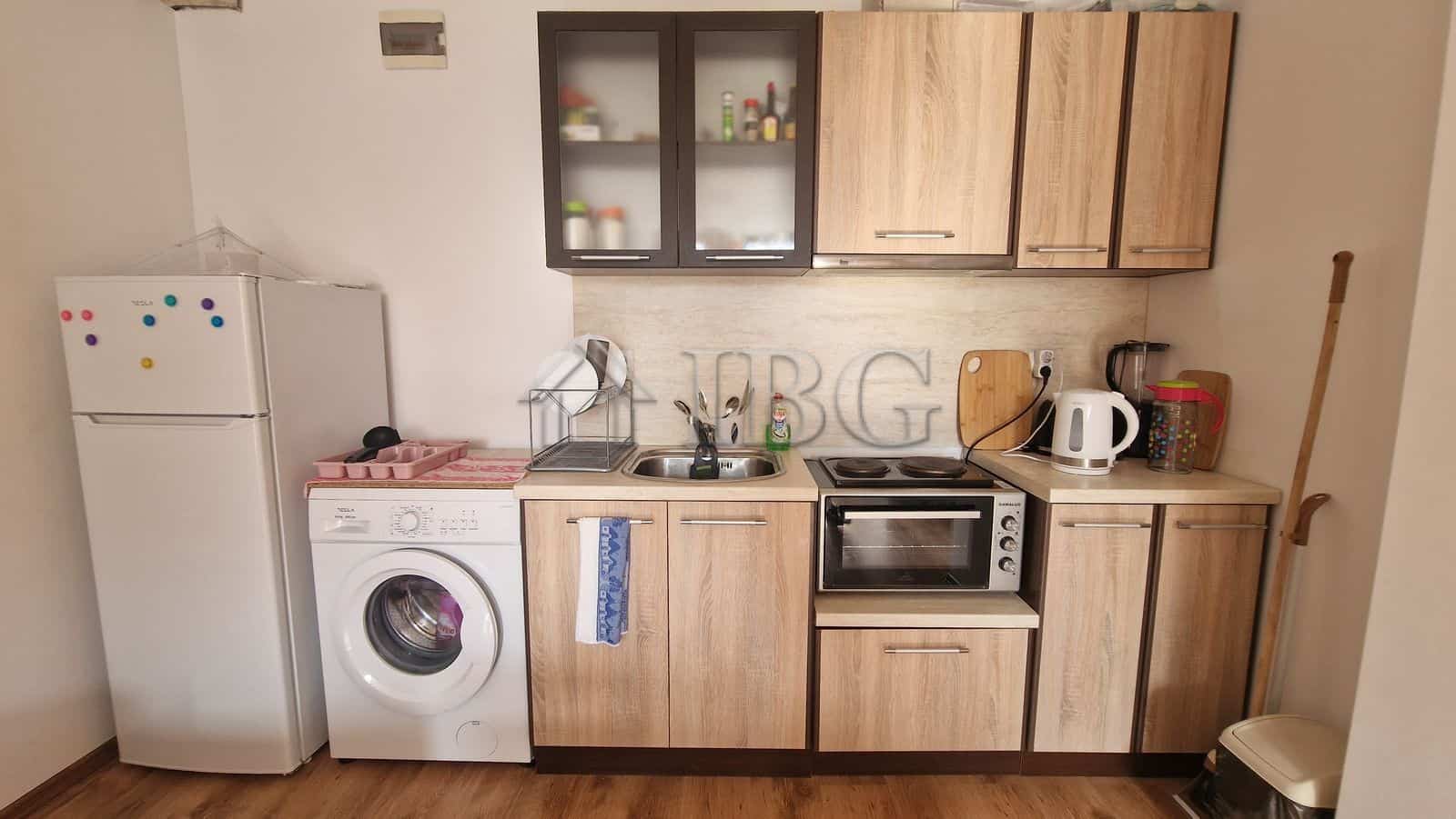 Interior view of a compact 1-bedroom apartment with kitchen and pool view in Sunny Beach area.