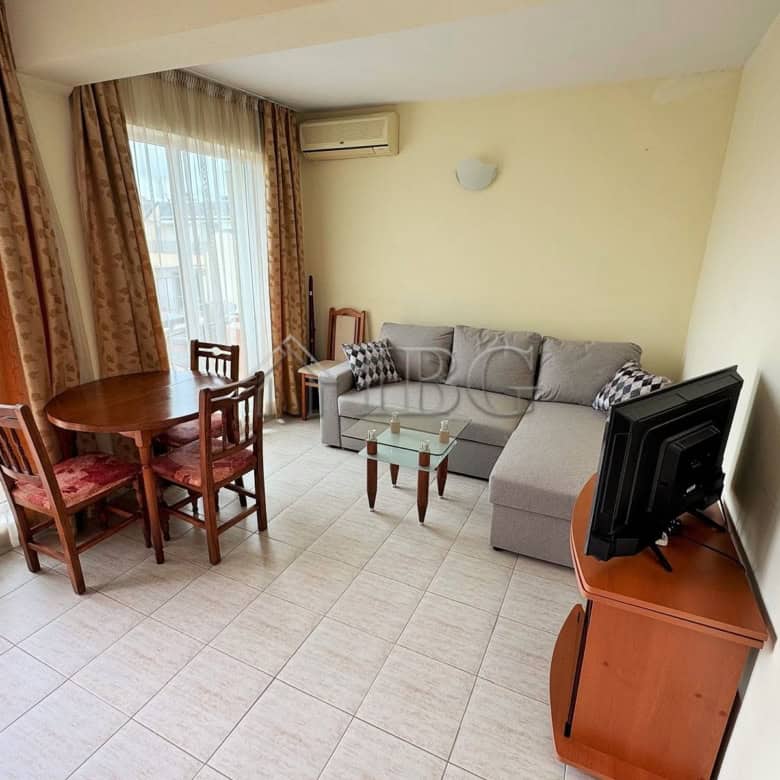Bright 2-room apartment with pool view, living area, dining space, and TV in Sunny Beach.