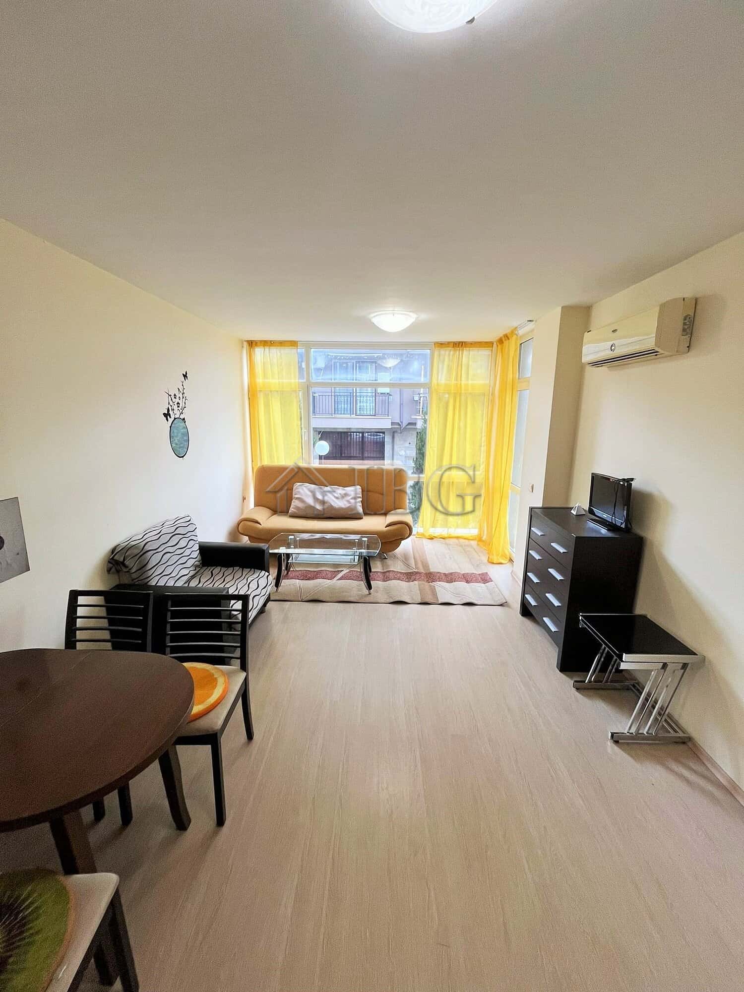 Furnished 1-Bedroom Apartment Near Cacao Beach Apartment with living room, sofa, dining table, and TV in Sunny Beach.