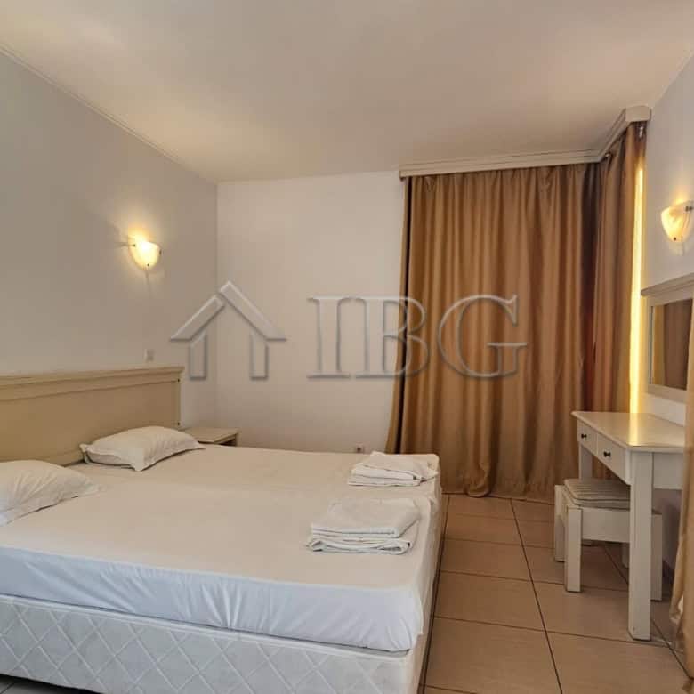 Bright interior of a no-maintenance fee apartment in Sunny Beach, Bulgaria, featuring a spacious bed.