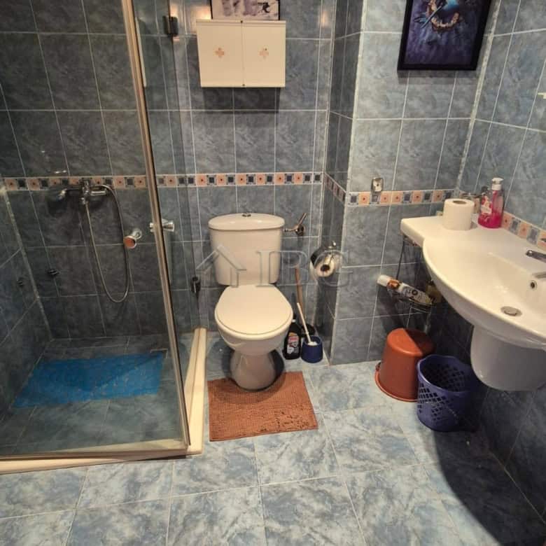 Bathroom with shower, toilet, and sink in a 1-bedroom apartment at Semiramida Gardens.