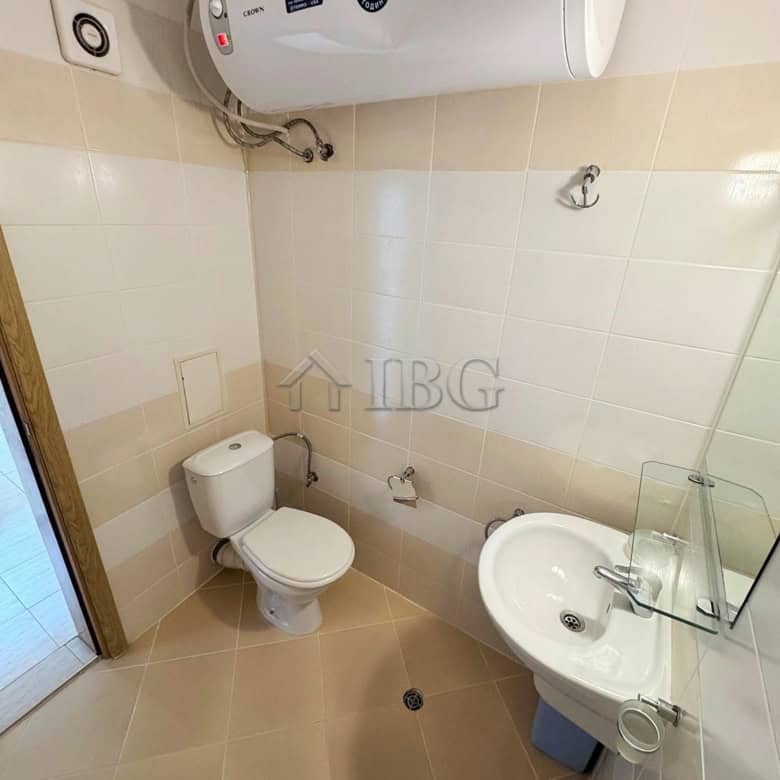 Clean, compact bathroom with water heater, toilet, and sink for comfortable living.