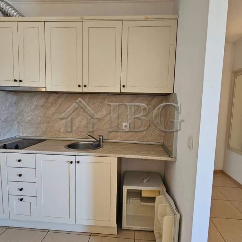 Modern kitchen with white cabinets and marble backsplash in Tria Apartments, Sunny Beach.