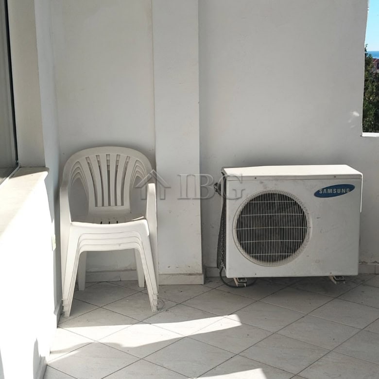 Balcony with plastic chair and air conditioning unit overlooking Sveti Vlas sea view.