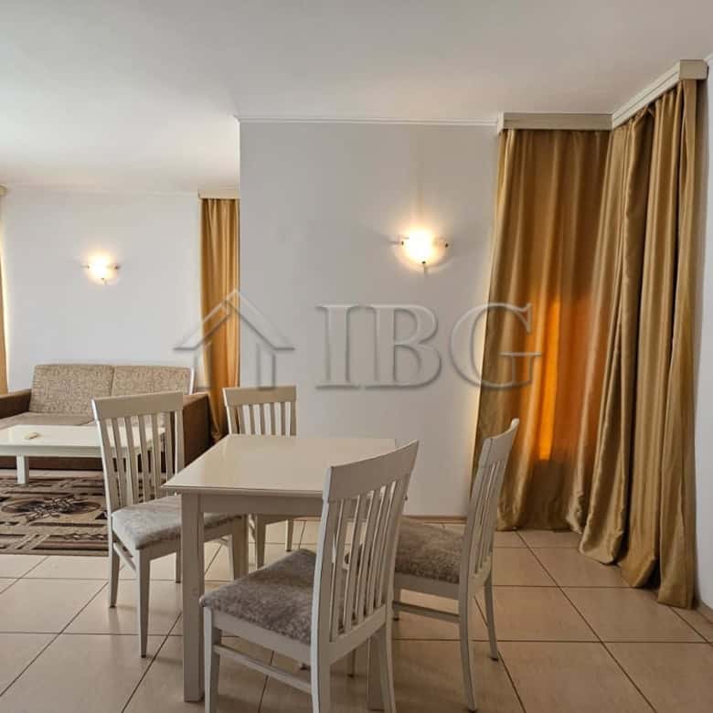 Bright living room with dining area and large windows in Tria Apartments, Sunny Beach.