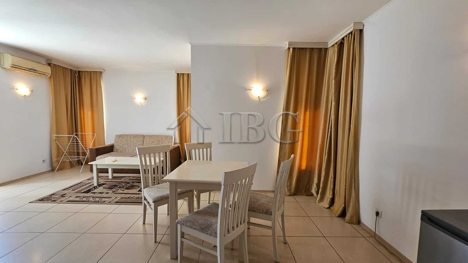 Bright living room with dining area and large windows in Tria Apartments, Sunny Beach.
